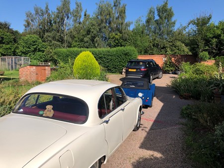 Picture of three cars: a cream 1966 Daimler Sovereign, a blue Morgan ARP4 and a Land Rover Discovery 5