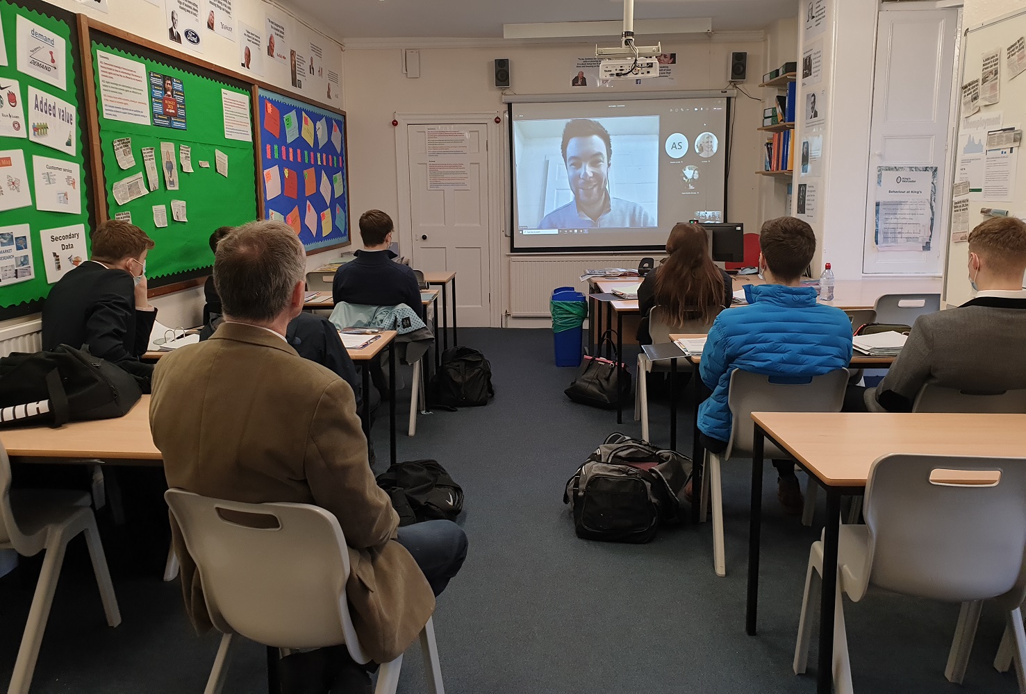 Joe Fowles on a screen talking to 6th form students in class